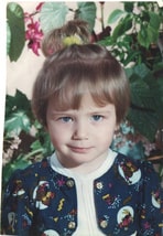 Old photo of a little girl in colorful clothing, reflecting family heritage